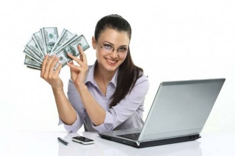 smiling girl with cash in the hand and laptop, cellphone